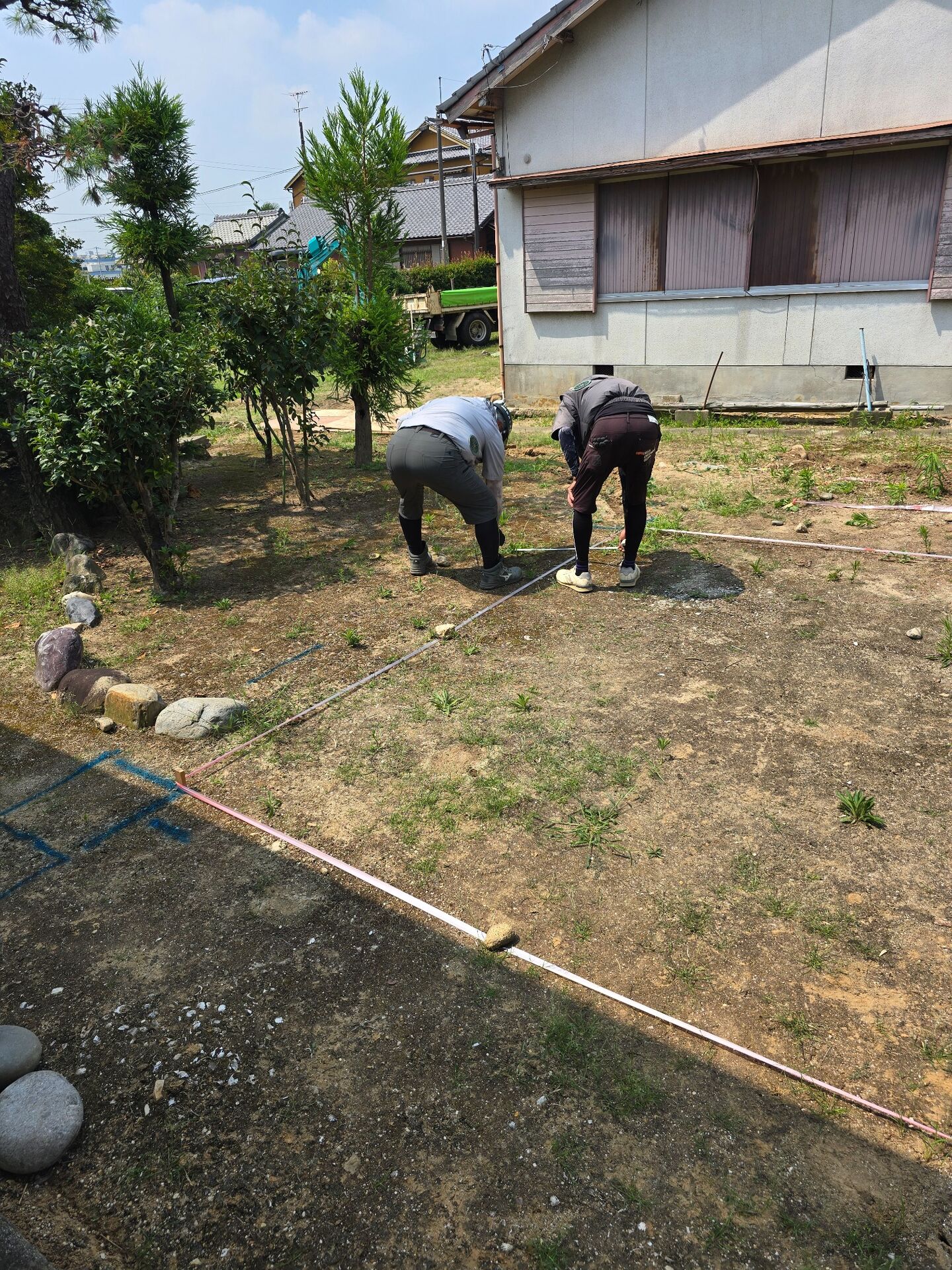   安城市S様邸のBBQ小屋工事で建物位置を確認するために寸法を測っている施工前の様子    