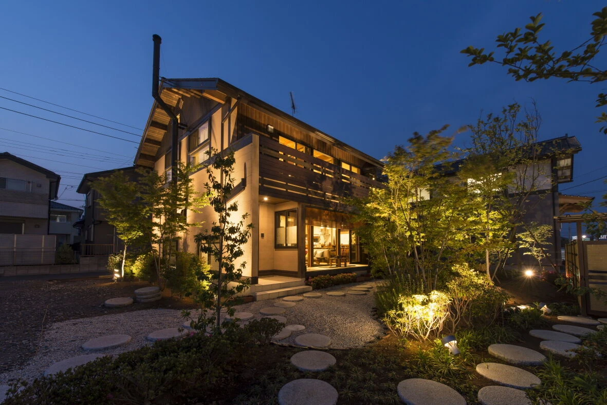 幸田町の注文住宅の夜景外観。木の質感を活かしたデザインと、やさしい照明が暮らしを包み込む落ち着いた住まい。